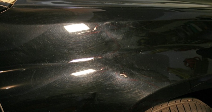Goresan lecet pada mobil hitam akibat mencuci mobil dengan alat dan metode yang salah